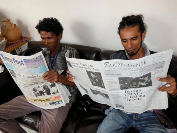 Timorese journalists check out their stories in two of the daily newspapers while  waiting for a media conference in Dili. Photo: David Robie.