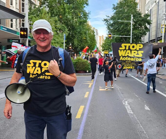 Palestine Solidarity Network Aotearoa's Neil Scott and protesters marching in the Stop Wars Aotearoa rally in Auckland's Queen Street
